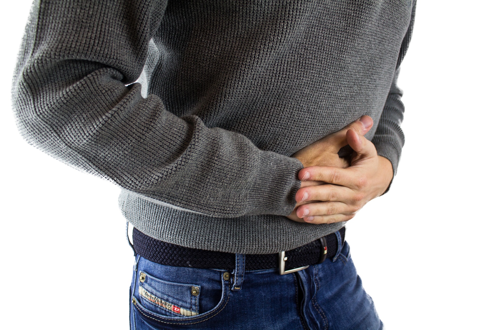 Man holding stomach to show connection between celiac disease and dental health