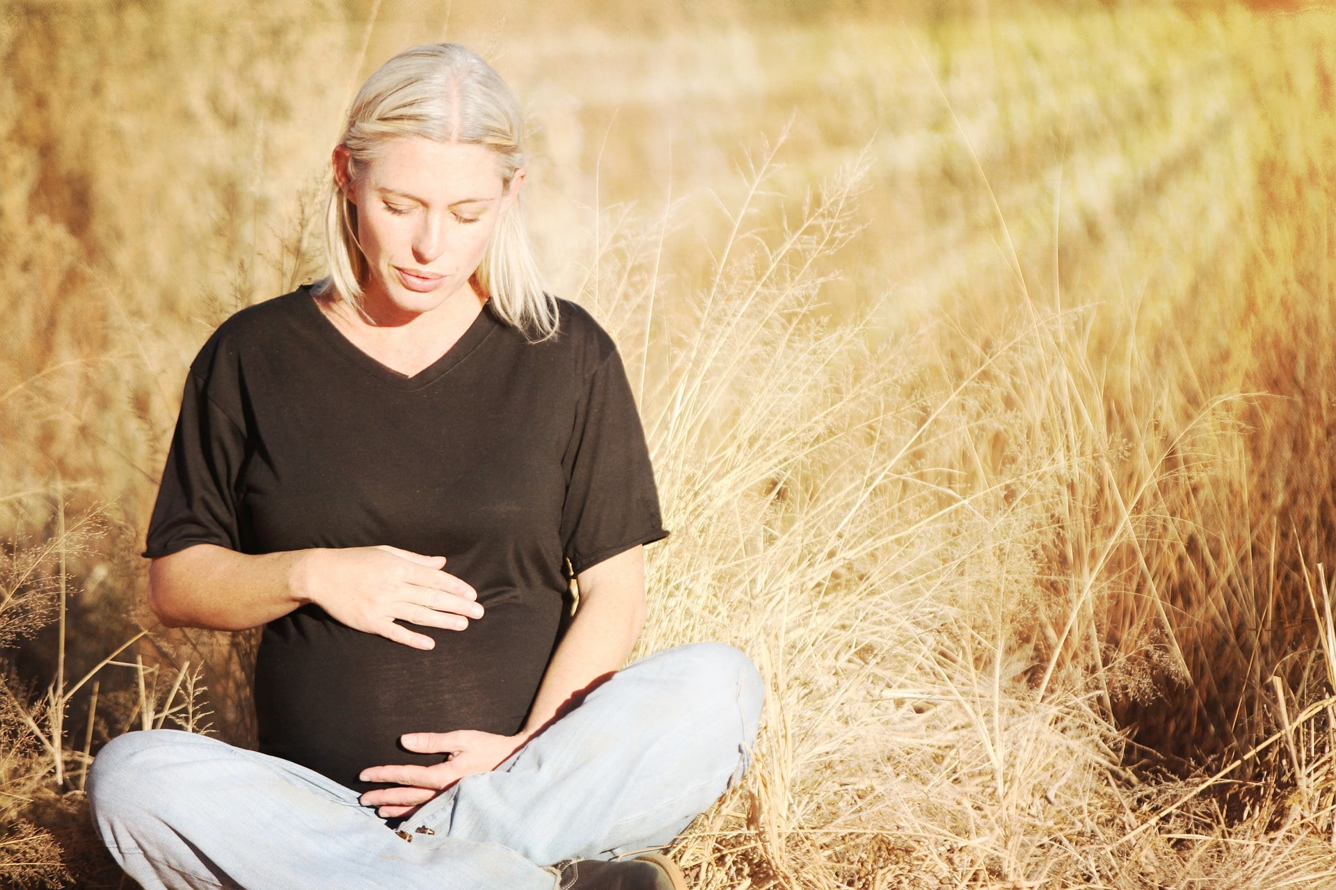 Pregnant woman sitting in field- dental care and pregnancy