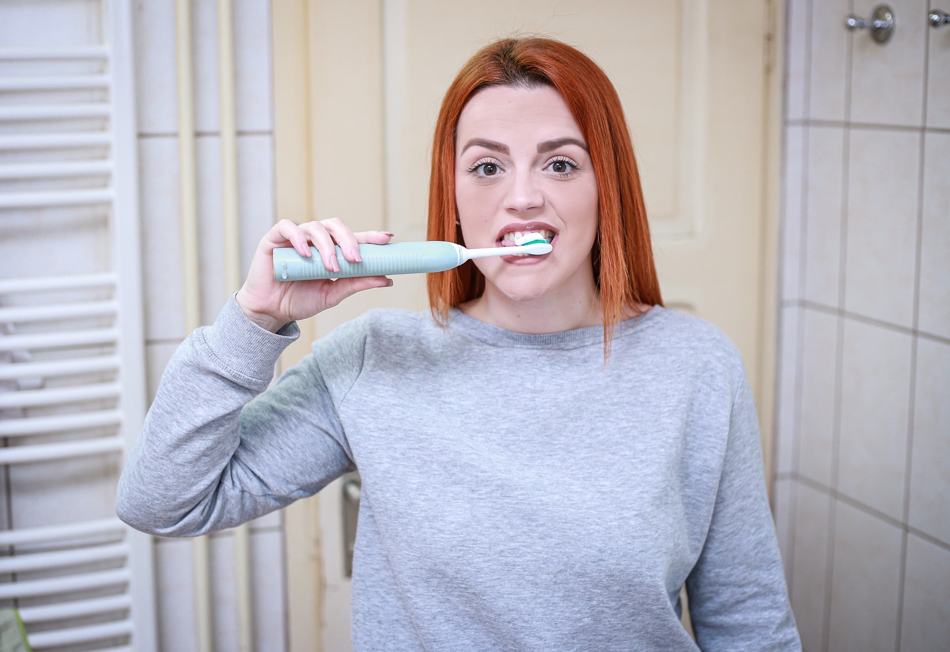 woman brushing teeth - what causes cavities