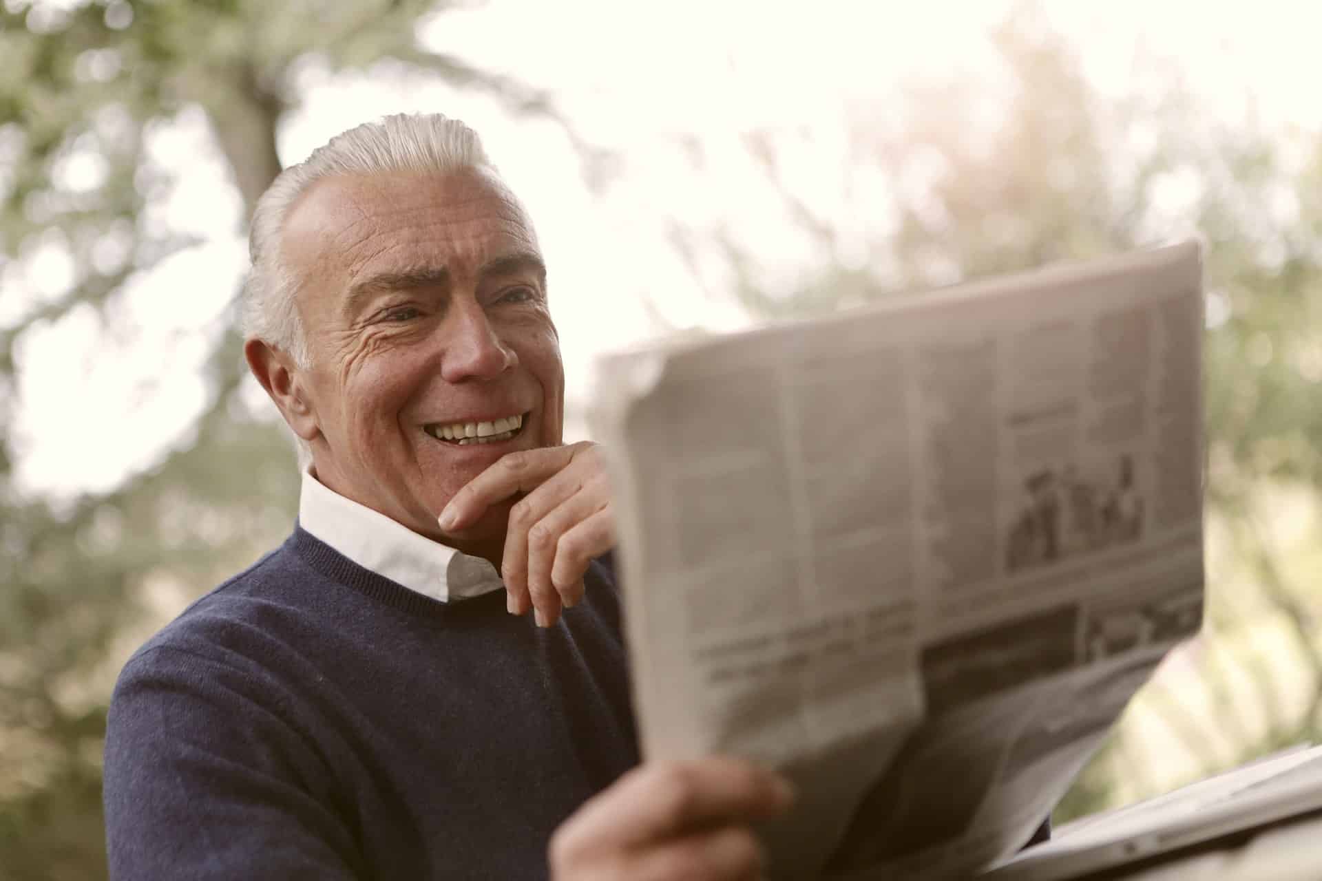 Can Anyone Get Dental Implants - older man reading newspaper