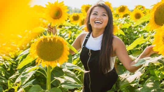 woman smiling in field of sunflowers