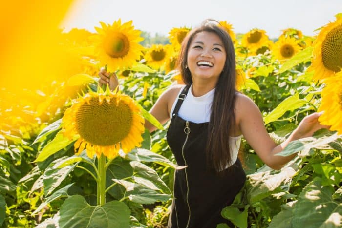 woman smiling in field of sunflowers