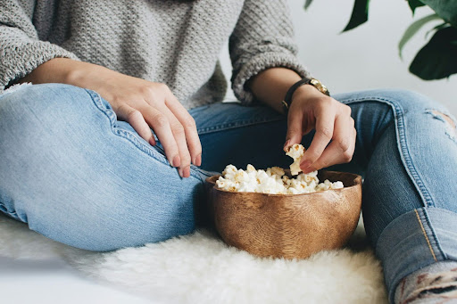 woman eating from a bowl of popcorn