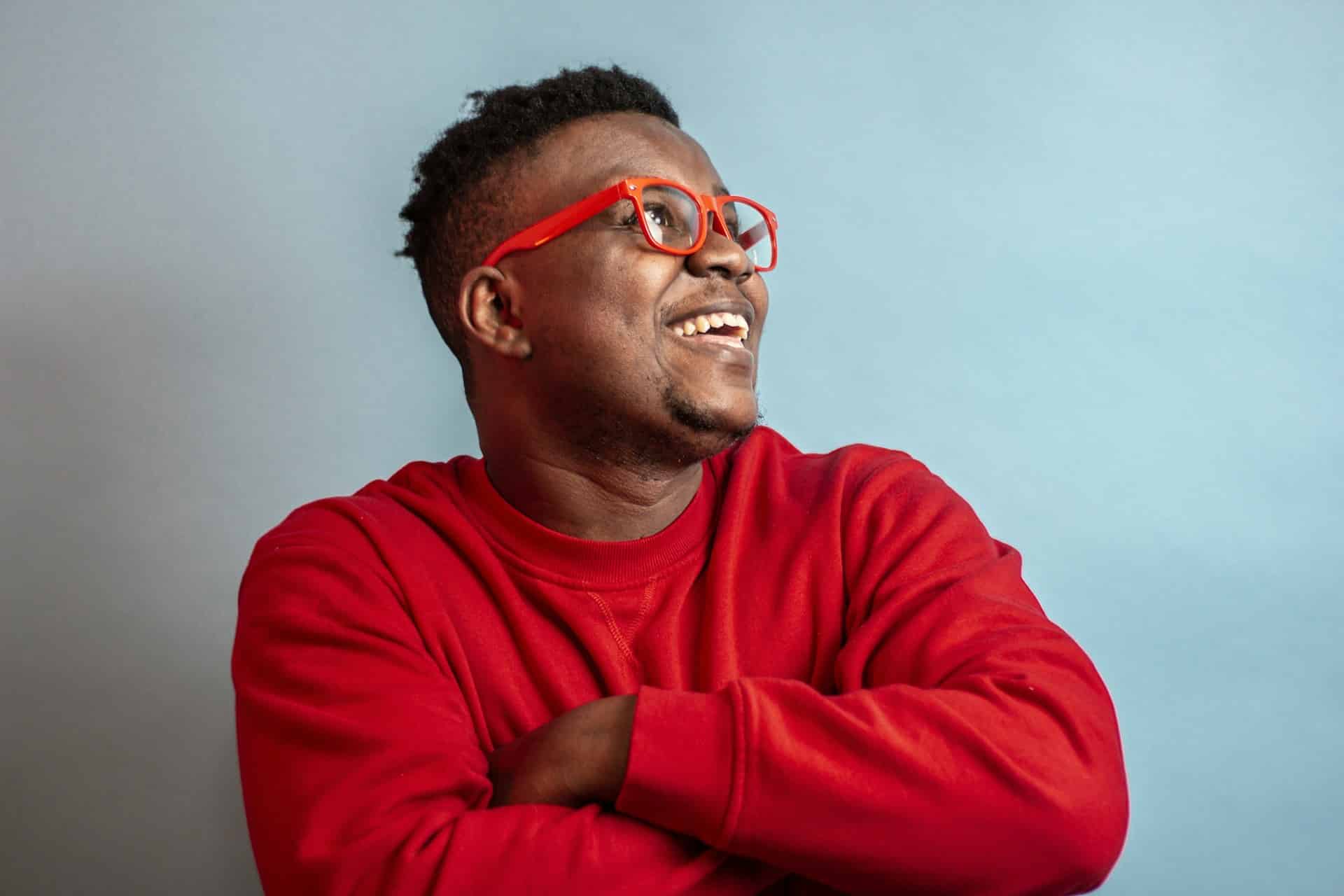 young man in red shirt and red glasses smiling