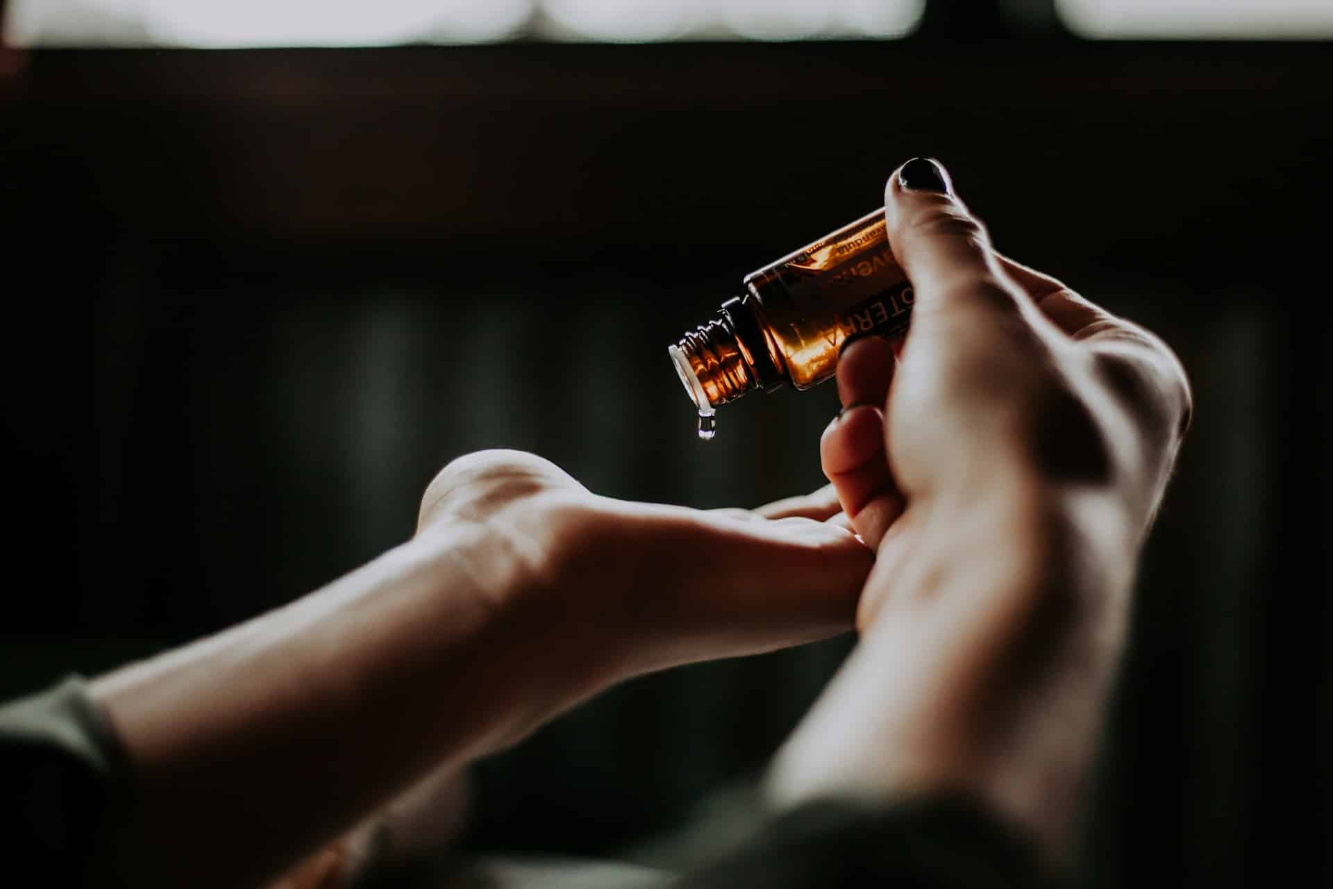 essential oil drop falling in hand